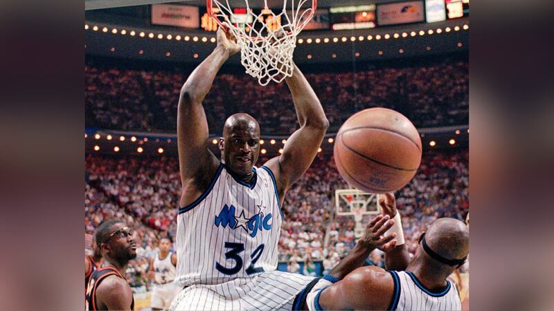 FILE -- Orlando Magic center Shaquille O'Neal (32) hangs from the rim after a slam-dunk during...