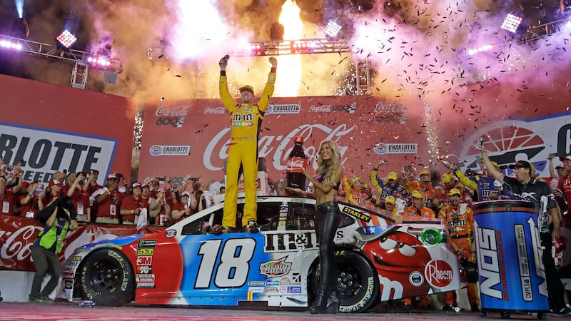 FILE - Kyle Busch celebrates after winning the NASCAR Cup Series auto race at Charlotte Motor...