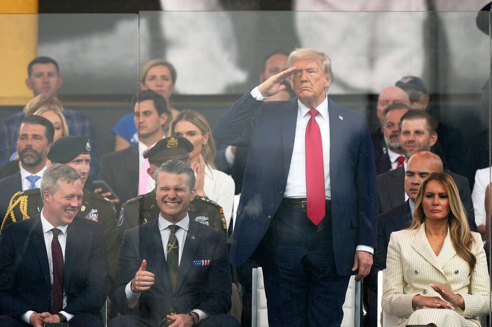 President Donald Trump salutes as attends a military parade commemorating the Army's 250th...