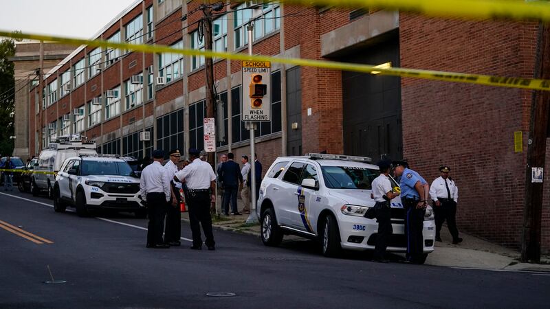 Investigators work the scene where multiple people were shot near a high school in...