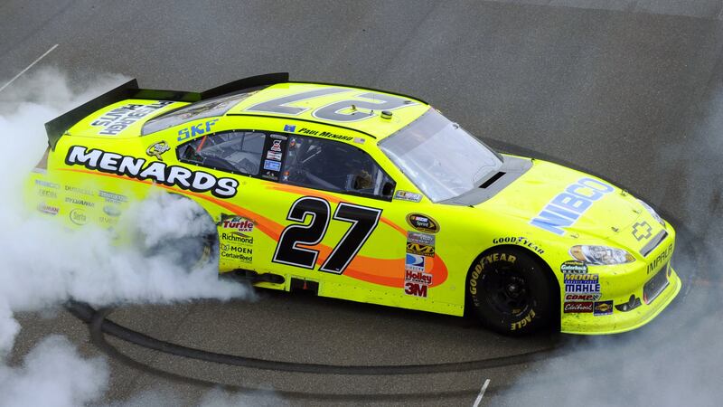 Paul Menard does a burnout on the front straight after winning the NASCAR Brickyard 400 auto...