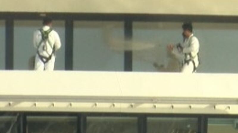 Employees work to disinfect the Norwegian Breakaway on Sunday after the cruise ship returned...